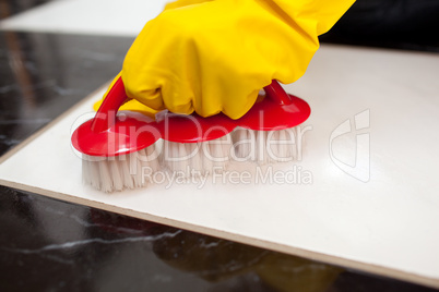 Close-up of a person cleaning a bathroom's floor