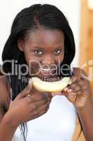 Smiling Afro-American woman eating melon