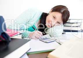 Smiling student doing her homework on a desk