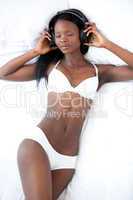 Relaxed woman in underwear listening music