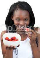Radiant Afro-american a woman eating strawberries