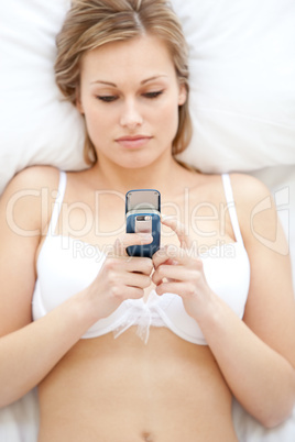 Concentrated woman in underwear sending a text