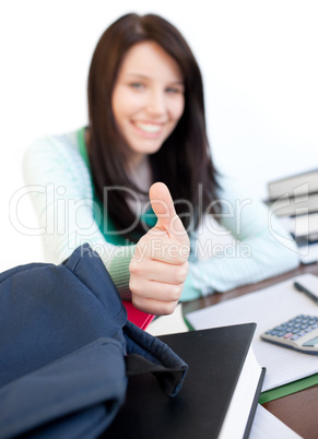 Attractive teen girl with thumb up studying