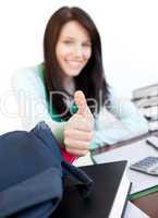 Attractive teen girl with thumb up studying