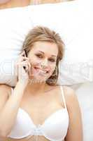 Cheerful woman in underwear talking on phone