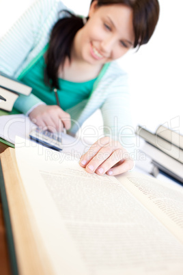 Cheerful student doing her homework on a desk