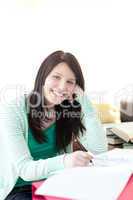 Smiling brunette student doing her homework