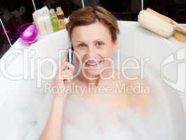 Beautiful woman talking on phone in a bubble bath