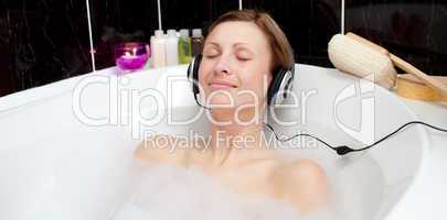 Relaxed woman listening music in a bubble bath