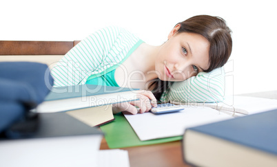 Attractive tired woman studying on a table