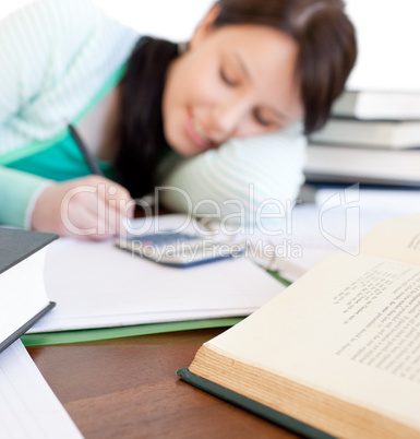 Brunette student doing her homework on a desk