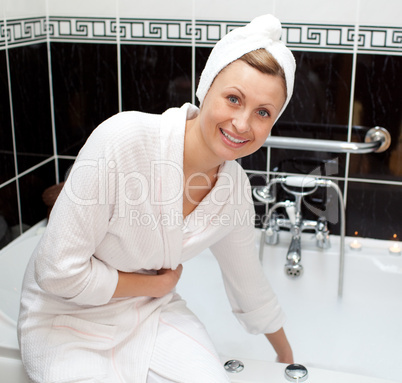 Smiling young woman preparing her bubble bath
