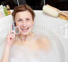Bright woman talking on phone in a bubble bath