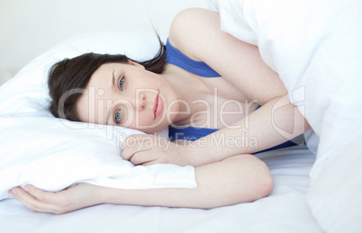 Delighted woman relaxing on a bed