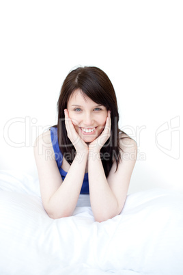 Portrait of a smiling woman sitting on her bed