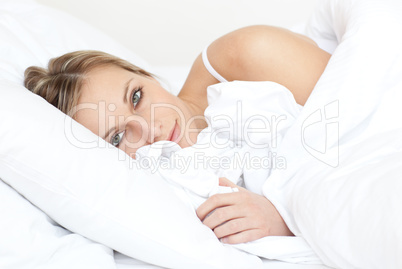 Radiant woman relaxing lying on her bed