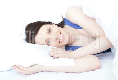 Cheerful woman relaxing lying on her bed