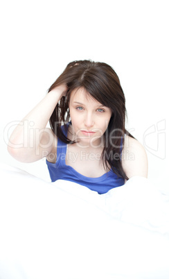 Portrait of a tired young woman sitting on her bed
