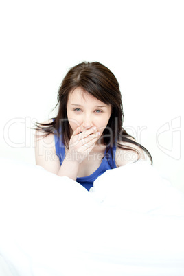 Radiant woman yawning sitting on her bed