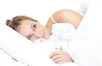 Delighted woman relaxing lying on her bed