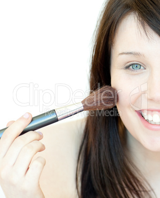 Cheerful woman using a powder brush