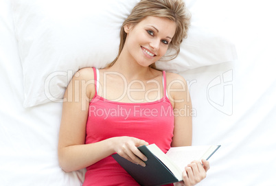 Cheerful blond girl reading a book