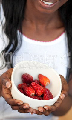 Afro-american a woman holding a bowl of strawberries