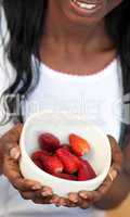 Afro-american a woman holding a bowl of strawberries