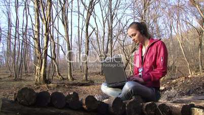Woman with a laptop in the forest