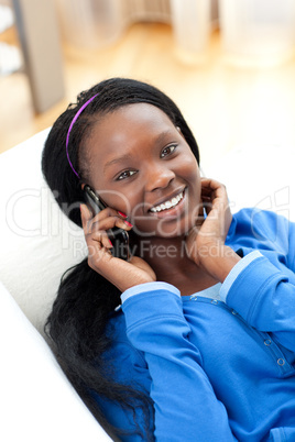 Charming woman on phone lying on a sofa