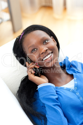 Laughing woman on phone lying on a sofa