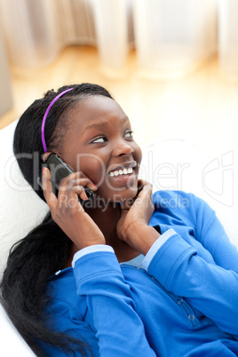 Afro-american woman on phone lying on a sofa