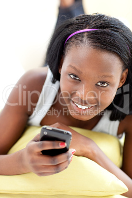 Attractive woman sending a text lying on a sofa