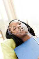 Exhausted teen girl studying lying on a sofa