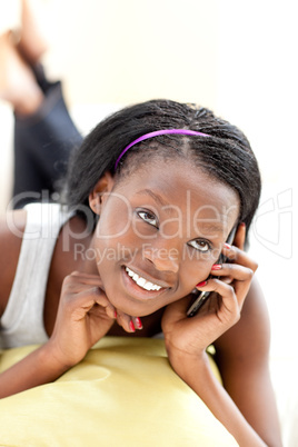 Radiant woman on phone lying on a sofa