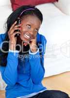 Pretty young woman talking on phone sitting on the floor