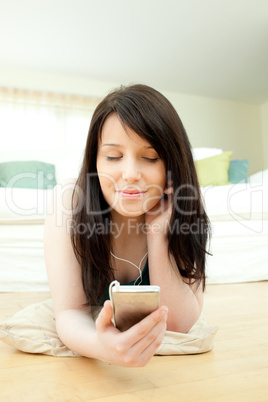 Caucasian woman listening music lying on the floor