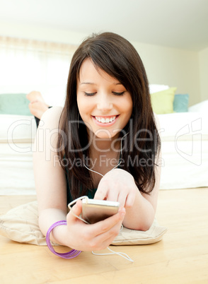 Charismatic woman listening music lying on the floor