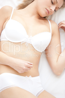Relaxed woman in underwear lying on bed