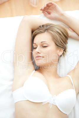 Dreamy woman in underwear lying on bed