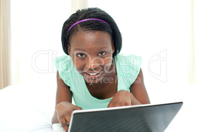 Charming woman using a laptop lying on her bed