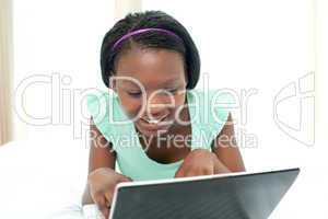 Young woman using a laptop lying on her bed