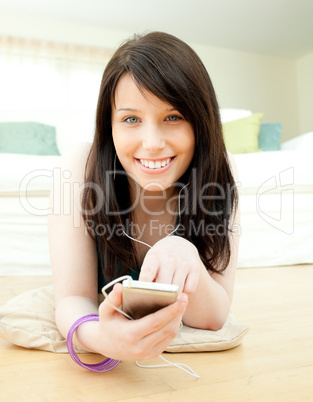 Delighted woman listening music lying on the floor