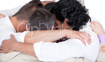 Confident business team hugging each other in a circle