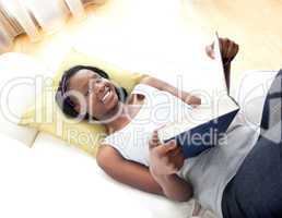 Happy teen girl studying lying on a sofa