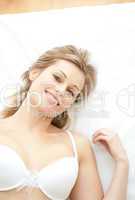 Radiant woman in underwear lying on bed