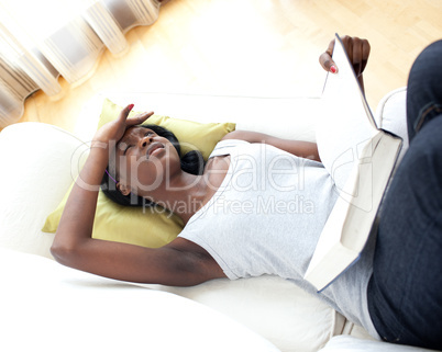 Unhappy woman reading lying on a sofa