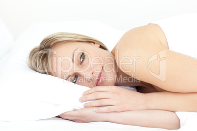 Bright young woman relaxing on her bed