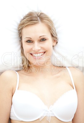 Smiling woman in underwear lying on bed