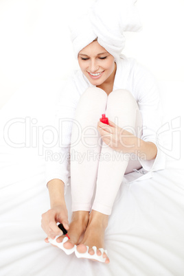 Jolly woman putting nail polish on her nails